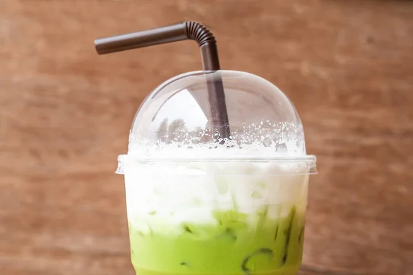 iced green matcha tea with milk wooden table