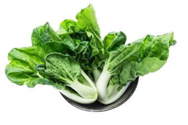 Tabakta bir sürü bok çuvalı, beyaz arka planda izole edilmiş. Asya yapraklı yeşil sebze.