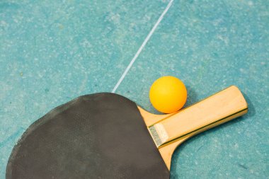 Ping pong kürekler ve Retro mavi ahşap arka planda topu. Raketler zaman mahvoldu