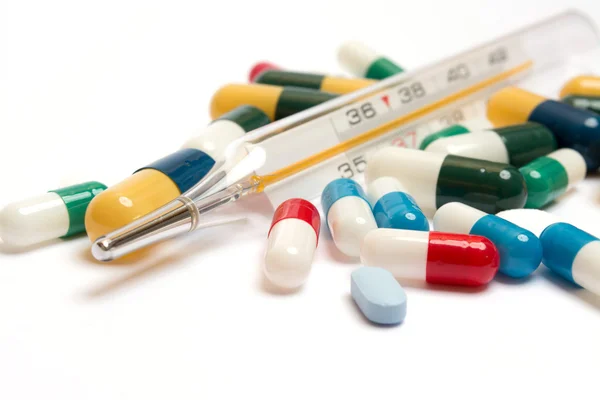 Varias pastillas con termómetro — Foto de Stock