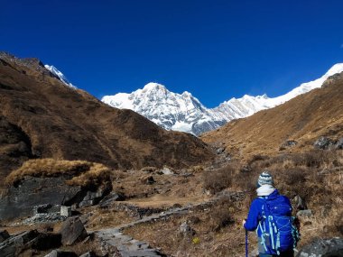 Annapurna Ana Kampı 'nda, Annapurna' nın tepesinde gezinen genç bir kadın.