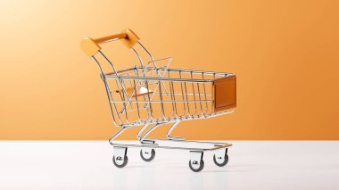 Alüminyum çerçeve ve Altın Kayısı döşemelerine sahip 3 boyutlu bir alışveriş sepeti veya tramvay, Altın Kayısı arka planına sahip beyaz bir üste yerleştirilir.