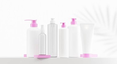 Şekerleme kapaklı beyaz losyon şişesi. Beyaz şapkalı temiz losyon şişesi. Farklı boyutlarda, beyaz arka plan ve palmiye yapraklı siluet içeren losyon şişeleri.