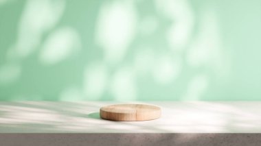 Dairesel ahşap bir podyum naneli arkaplanı olan bir çimento tabanına yerleştirilir. Yaprakların doğal gölgeleriyle aydınlatma