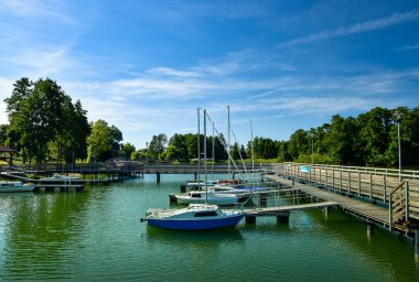 Güneşli bir günde bir gölde yüzen rıhtımdaki küçük tekneler.