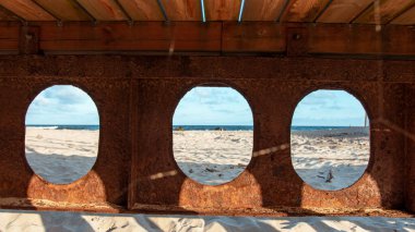 Baltık Denizi 'nde bulunan köprünün paslı kirişleri, güneşli bir günde sahili görmek.