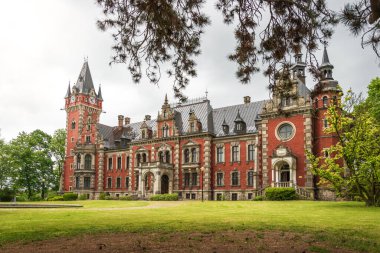 Plawniowice 'deki saray ve park kompleksi. Birçok kulesi olan zengin dekore edilmiş bir bina. Tıkaçlı tuğla cephesi, patentli çarşaf kaplı çatı