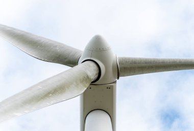 Bulutlu gökyüzüne karşı yel değirmeni türbini - yakın plan.