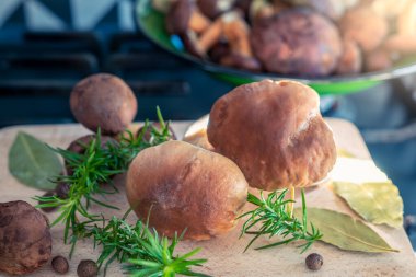 Baharatlarla çevrili bir kesme tahtasına mısır gevrekleri, bir gaz ocağının ızgarasına yerleştirilmiş bir tahta, modern bir ev mutfağı.