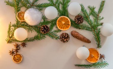 Noel süslemeleri beyaz Noel topları, ladin lahanaları, koniler, anason ve kurutulmuş portakallar ve limonlardan yapılmıştır. Üst Manzara. Beyaz arkaplan.