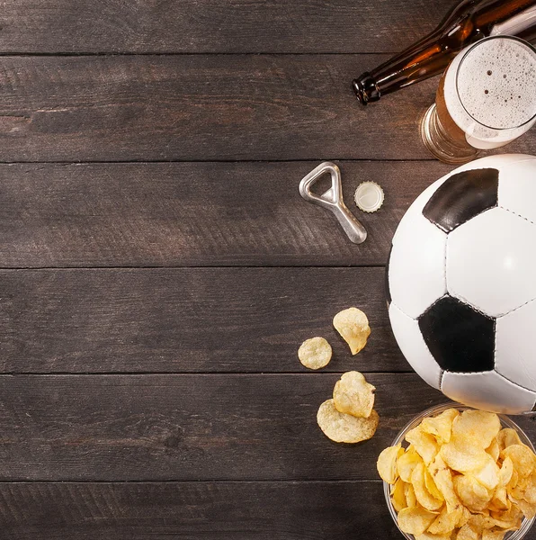 glass of beer and soccer ball. wooden space for text