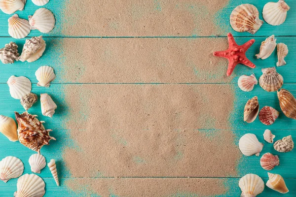 Frame of seashellson on sand wooden background. Space for text — Stock Photo, Image