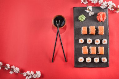 suşi yemek çubukları, zencefil, soya, wasabi ve sakura plaka üzerinde