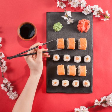 Elini tut karanlık yemek masasında suşi ile siyah sopa