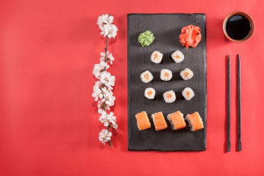 suşi yemek çubukları, zencefil, soya, wasabi ve sakura plaka üzerinde