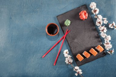suşi yemek çubukları, zencefil, soya, wasabi ve sakura plaka üzerinde
