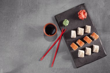 suşi yemek çubukları, zencefil, soya, wasabi ve sakura plaka üzerinde