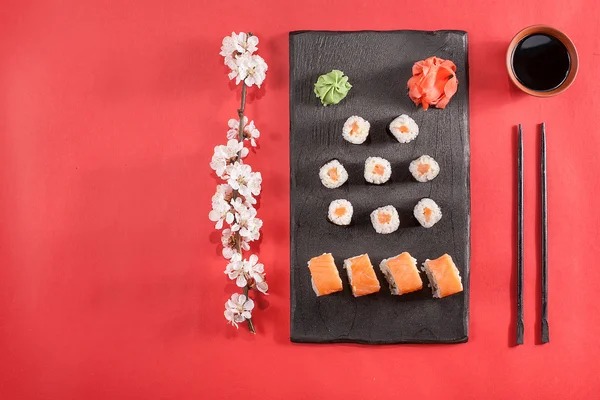 suşi yemek çubukları, zencefil, soya, wasabi ve sakura plaka üzerinde