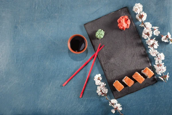 suşi yemek çubukları, zencefil, soya, wasabi ve sakura plaka üzerinde