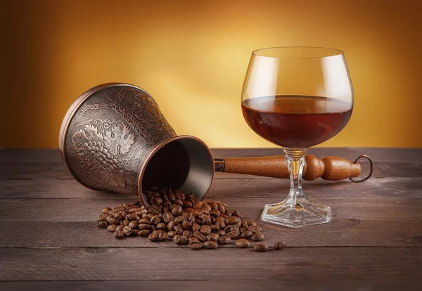 Cezve with coffee beans and glass of whiskey — Stock Photo, Image