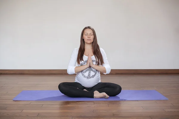 Kobieta w ciąży robi joga pomieszczeniu — Zdjęcie stockowe