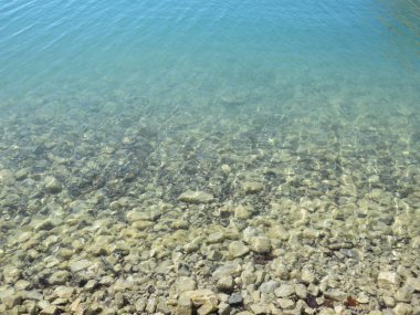 Gölün dibindeki taşlar, suyun sığ sulardan derin sulara akması gibi.