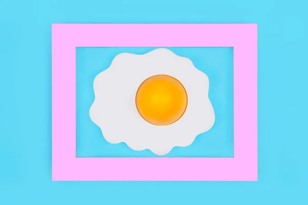 Telur Goreng Dalam Bingkai Merah Muda Dengan Latar Belakang Biru — Stok Foto