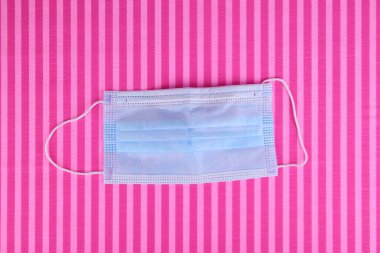 Pastel pembe arka planda koruyucu yüz maskesi