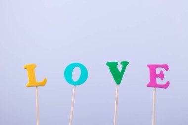 Renkli harflerle yazılmış bir aşk kelimesi. Minimal Mutlu Sevgililer Günü konsepti.