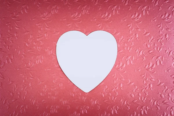 White heart on pastel textured pink background. Minimal Valentines day concept.