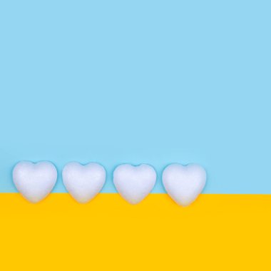 Sarı ve mavi arka planda beyaz kalpler. Sevgililer Günü Asgari Kopyalama Alanı.