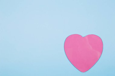 Pastel mavi arka planda pembe kalp. Minimal Sevgililer Günü konsepti.