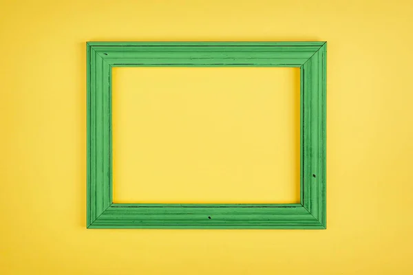 Simple green frame on bright yellow background. Minimal border composition.