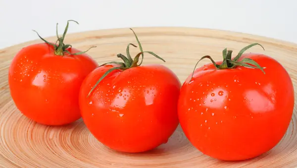 Pomodori rossi freschi su piatto di legno — Foto Stock