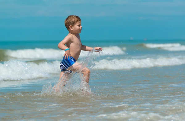 Kis fiú gyermek fut át a tenger a száját — Stock Fotó