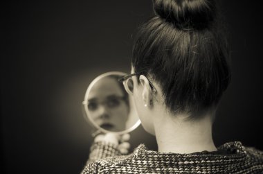 business woman looking in the mirror and reflecting on herself