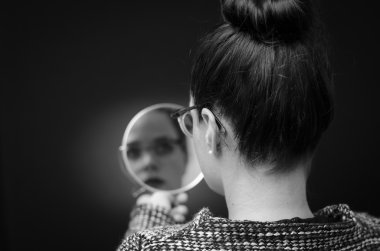 business woman looking in the mirror and reflecting on herself