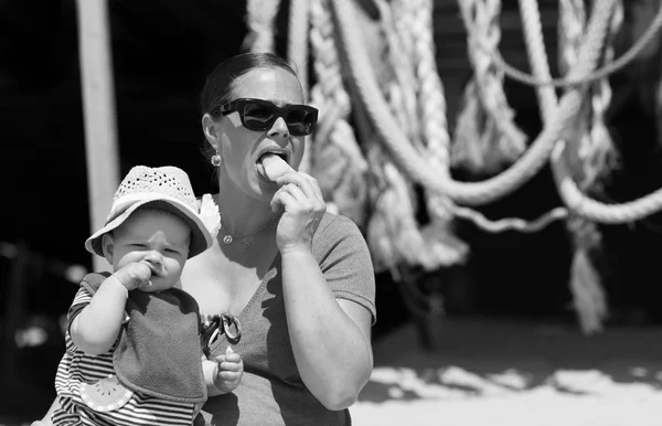 Kis baba lány ül az anyjával eszik kalapját aan-fagylalt a tengerparton — Stock Fotó