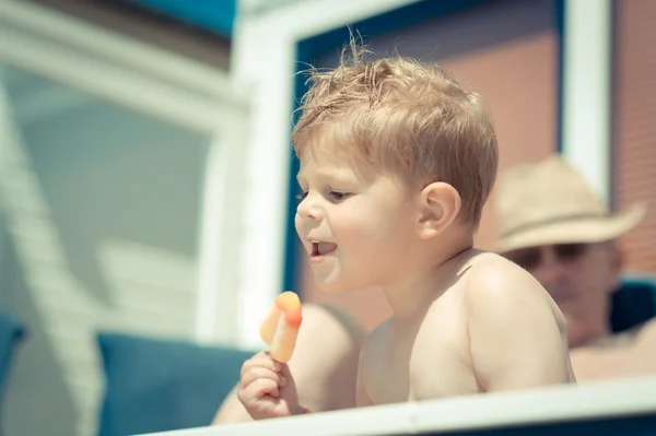 Kisfiú eszik egy fagylalt a tengerparton — Stock Fotó