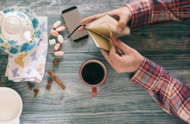 Bir kitap okumak ve notlar günbatımı üzerinde ahşap masada adam.