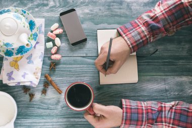 Kahve, notlar ve akıllı tahta masada kitap okurken erkek 