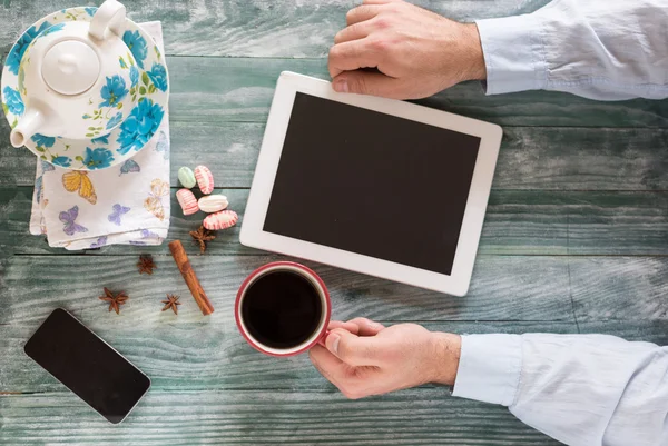 hand using mockup tablet similar to ipad style on wood desk whit