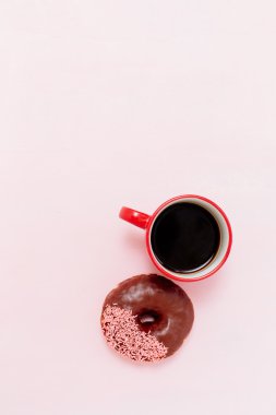 Kahve ve donut pembe bir arka plan üzerinde