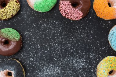 Taş masada renkli çörekler. Kopyalama alanı olan üst görünüm