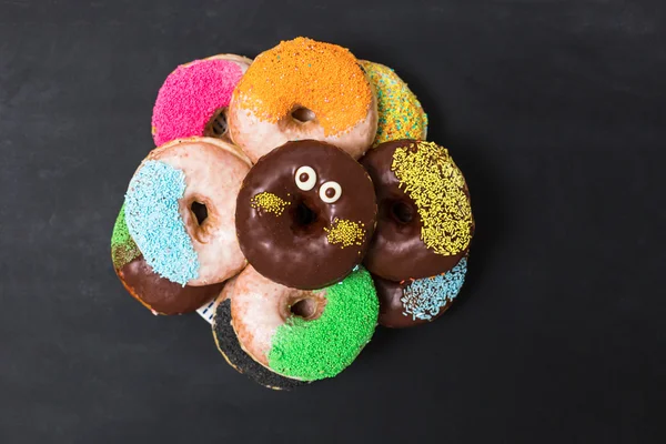 Donuts with different powder on a black wooden background — Stock Photo, Image