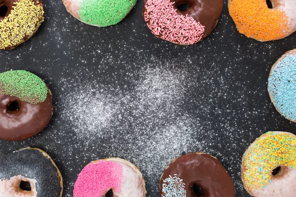 Colorful donuts on stone table. Top view with copy space — Stock Photo, Image