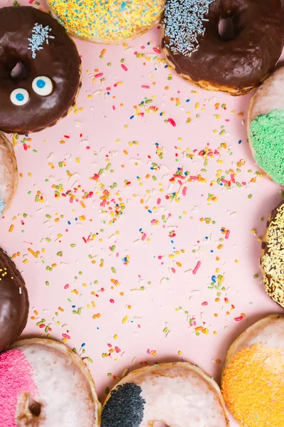 Assorted donuts on a pastel pink background, copyspace — Stock Photo, Image