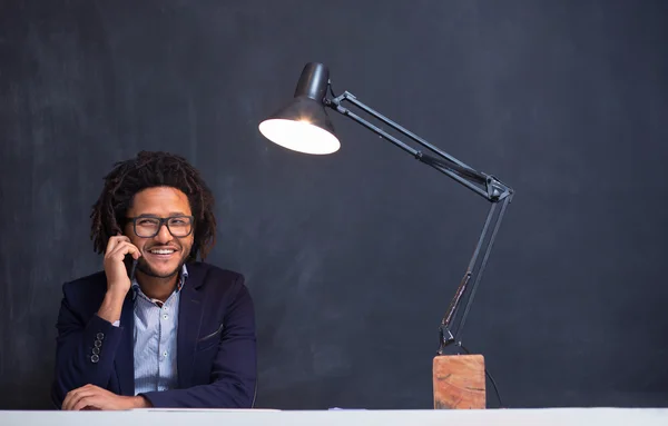 Portrait d'un homme souriant avec un téléphone portable assis au café usin — Photo