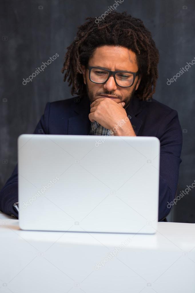 Portrait of smart businessman busy working at desk, using mobile