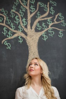 Çizim tebeşir para ağacı önünde mutlu sarışın iş kadını